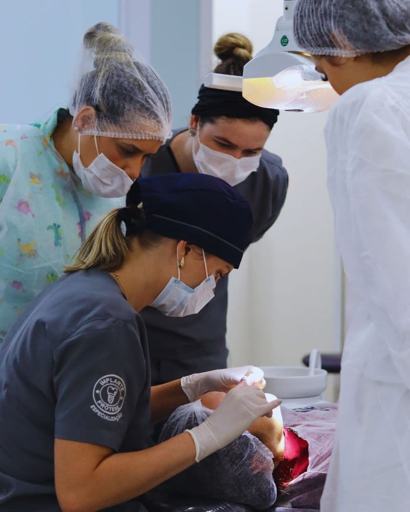 Equipe paramentada durante procedimento clínico supervisionado